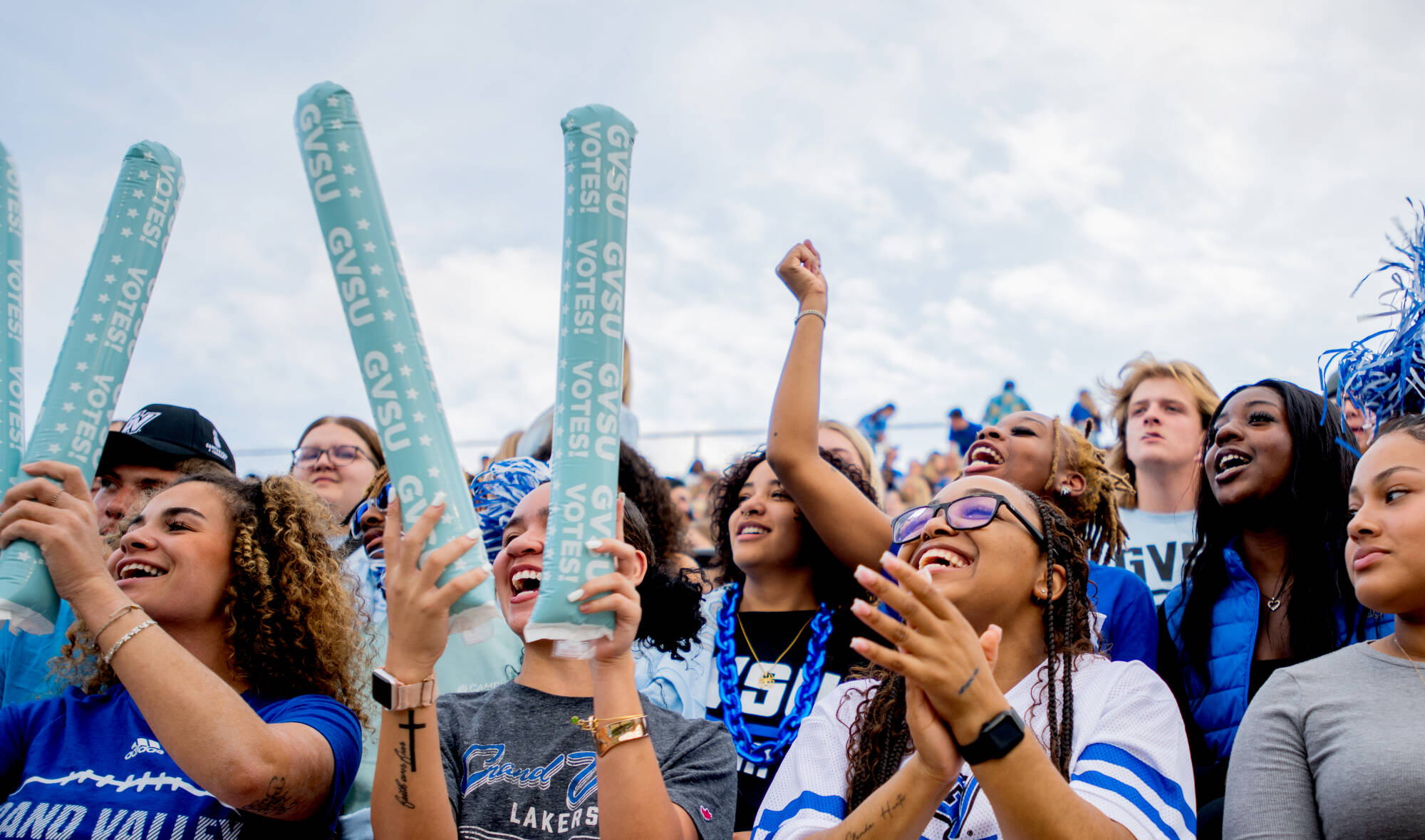 Students cheer in the stands at a Grand Valley men's football game.